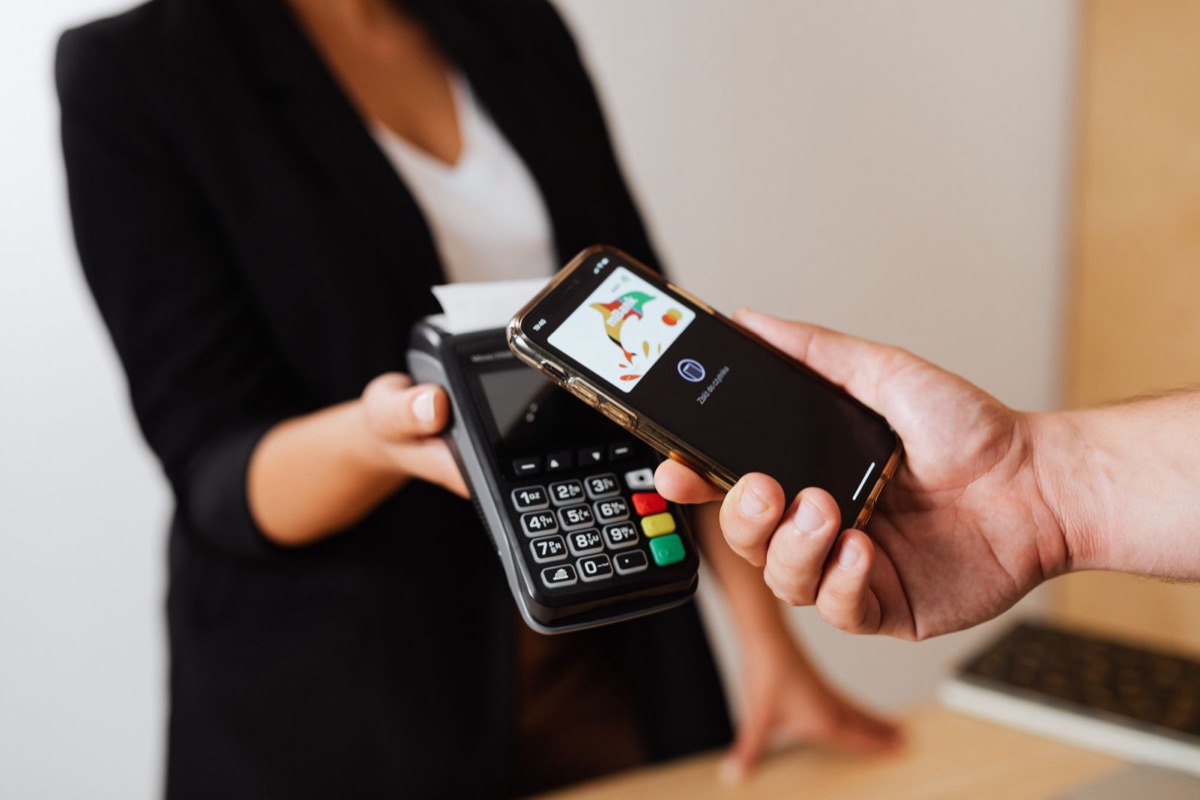 Someone paying by tapping a phone on a card reader